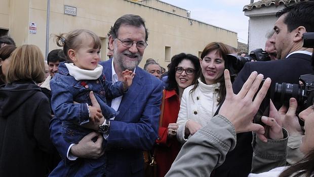 Rajoy se hace fotos con una niña en brazos en las calles del pueblo