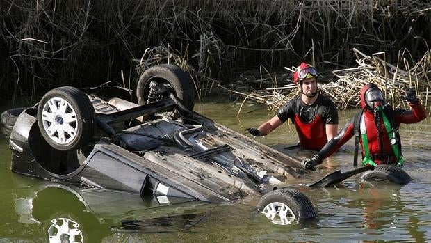 Bomberos trabajan para rescatar a uno de los fallecidos del vehículo que cayó a una acequia en Dueñas (Palencia)