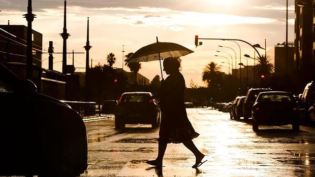 Una mujer se protege de la lluvia en Valencia en una imagen de archivo