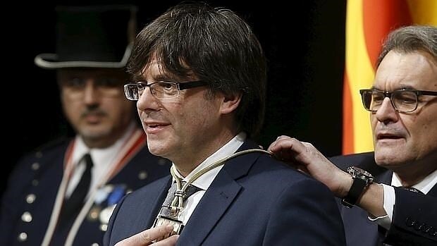 Artur Mas impone al nuevo presidente de la Generalitat, Carles Puigdemont, la medalla representativa del cargo
