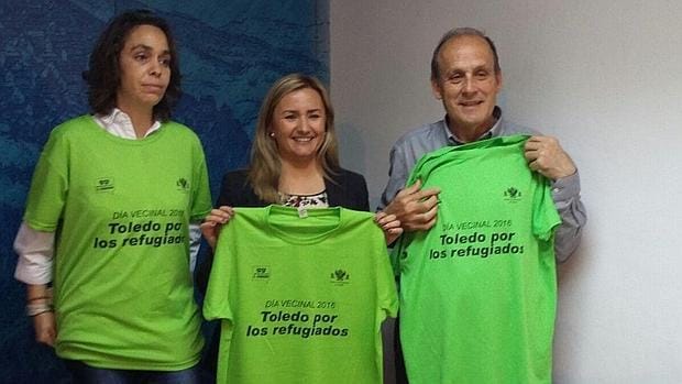 Las concejales Helena Galán y María Teresa Puig, junto con Luis Álvarez, sostienen la camiseta conmemorativa del Día Vecinal que se celebrará este domingo