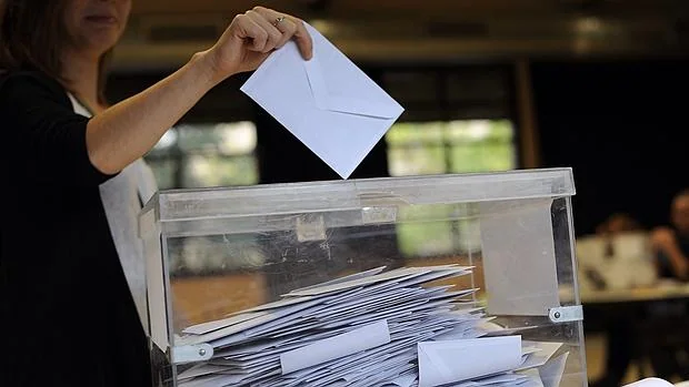 Una mujer introduce la papeleta en la urna en las elecciones catalanas del 27-S