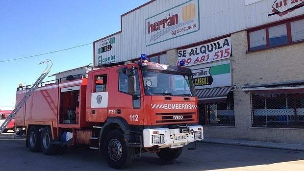 Los bomberos tratan de apagar el fuego de una nave agropecuaria en León