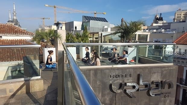 Sesión de yoga en la azotea del Hotel Urban, con las vistas del centro de Madrid al fondo