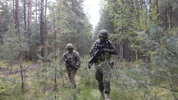 Un militar español (en primer plano) y otro británico en en una maniobra en los bosques de Zagan