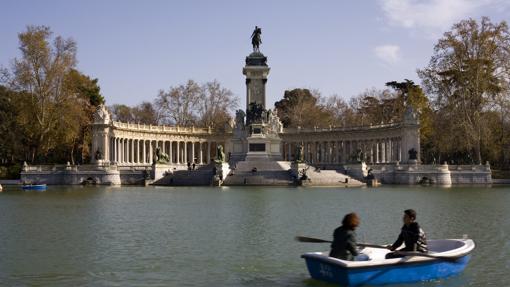 Estanque del parque del Retiro, dos personas reman en barca por el lago