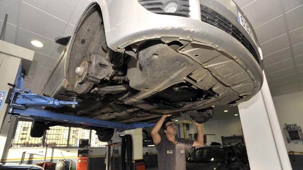 Un trabajador, durante una reparación en un taller