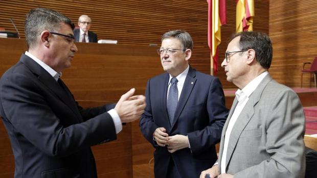 Puig, entre el presidente de las Cortes y el conseller de Hacienda, en el pleno de este jueves