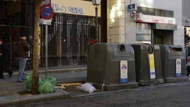 Varias bolsas de basura fuera de los contenedores de basura en la calle Fuencarral
