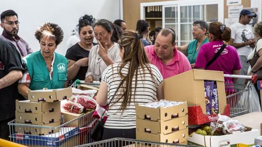 Varios usuarios recogen alimentos en la sede de la entidad