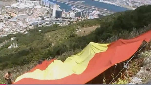 Un miembro de VOX despliega una bandera española de gran tamaño a escasos metros de la cima del Peñón