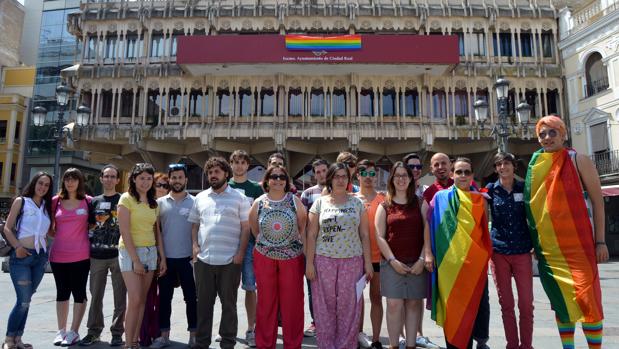 Miembros de la Asociación LGTBQ y los ediles de Ciudad Real delante de la bandera que se ha instalado en la fachada del Ayuntamiento de Ciudad Real