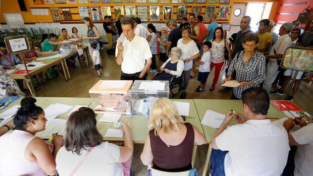 Varias personas se disponen a votar en un colegio electoral