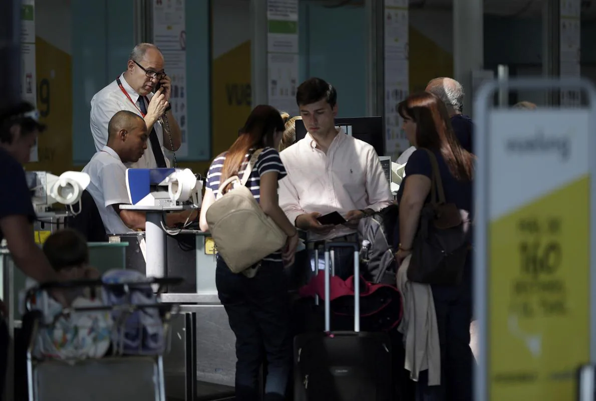 Personal de facturación de Vueling atiende a los viajeros en el aeropuerto de El Prat