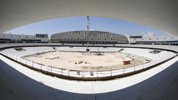 Vista general del nuevo estadio del Atlético de Madrid, aún en obras; al fondo, la antigua grada de la Peineta