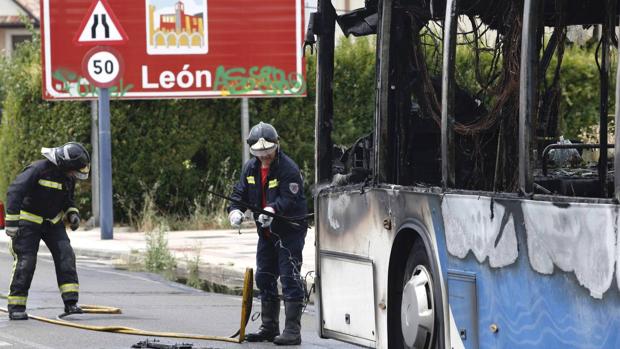 Los bomberos tratan de apagar el fuego del autobús urbano