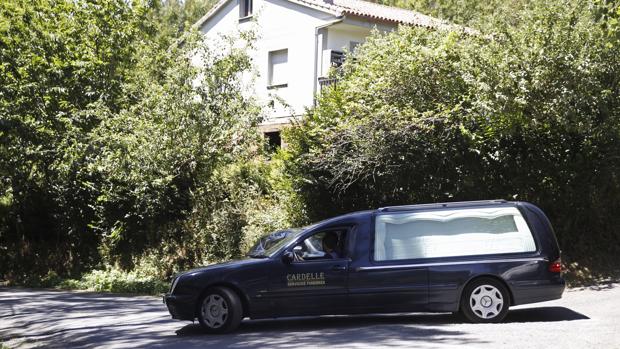 Un coche fúnebre abandona la casa de Arzúa donde fueron localizados muertos los dos ancianos de 84 y 98 años