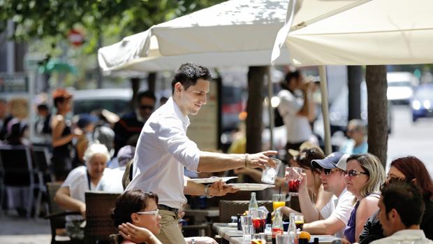 Imagen de un camarero atendiendo a una mesa en una terraza de la Plaza del Ayuntamiento