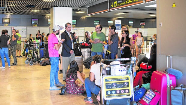 El cónsul de México, de traje y corbata, habla ayer con algunos de los afectados en la T1 de Barajas