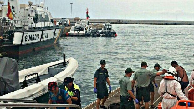 Efectivos de la Guardia Civil con los rescatados en el puerto de Alicante.