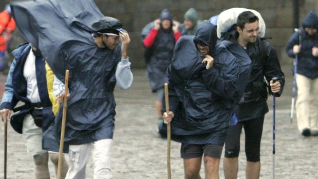 Peregrinos tratando de refugiarse de la lluvia