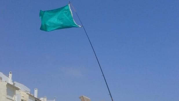 Bandera indicadora del estado del agua para el baño en Torrevieja, atada a una caña de pescar.