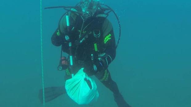 Un buceador de la Guardia Civil con restos hallados en el mar