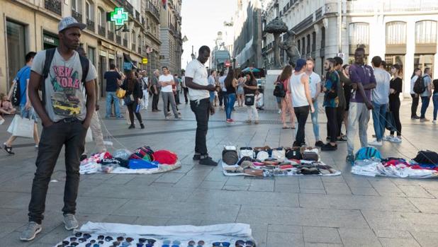 Varios manteros despliegan su muestrario en la Puerta del Sol