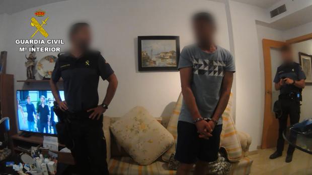 El presunto traficante, con dos agentes de la Guardia Civil en el domicilio compartido con su cómplice