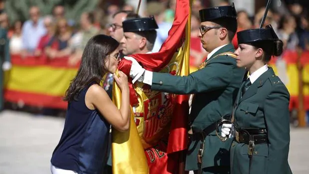 Una mujer besa la Enseña Nacional durante la jura de bandera