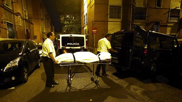 Los servicios funerarios trasladan el cadáver de la víctima, anoche, en Puente de Vallecas