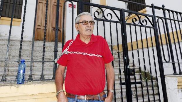 Francisco Gómez, encadenado hoy en la verja exterior de la sede local socialista de Mérida