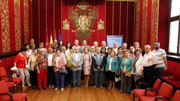 La alcaldesa de Toledo, Milagros Tolón, y el concejal de Servicios Sociales, Javier Mateo, con decenas de personas mayores en la sala capitular del Ayuntamiento