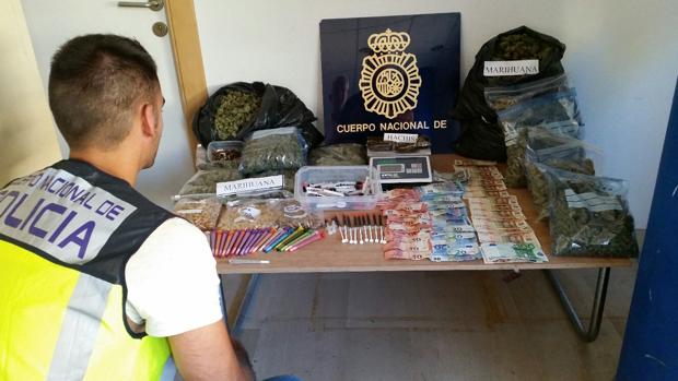 Un agente obxerva el material incautado en el registro al club de fumadores ilegal en Alicante