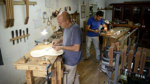 Mariano Conde y su hijo, en su taller de guitarras de Madrid