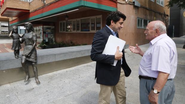 David Pérez (i), charla, en una imagen de archivo, con un vecino de Alcorcón