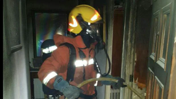Un bombero trabaja en la extinción del fuego en el interior de la vivienda en Canals