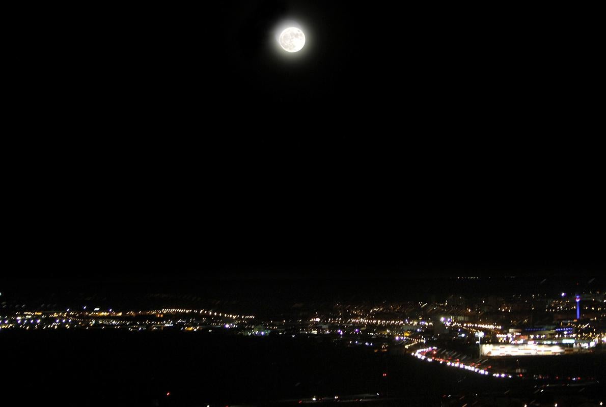 La superluna este lunes por la noche y, debajo, el Polígono de Toledo; la imagen está tomada desde la Biblioteca del Alcázar de Toledo