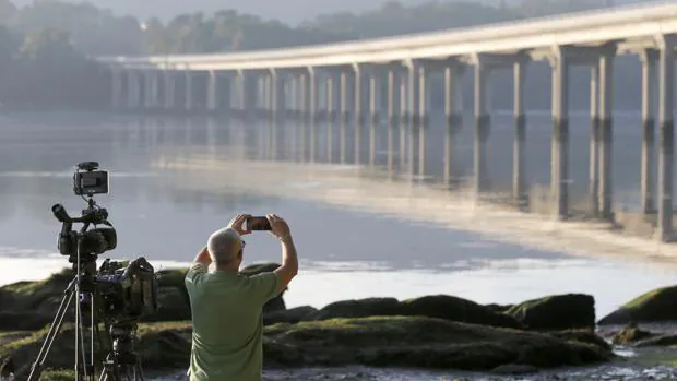 Un hombre fotografía el puente de Taragoña, cerca de donde se halló el móvil de Diana Quer