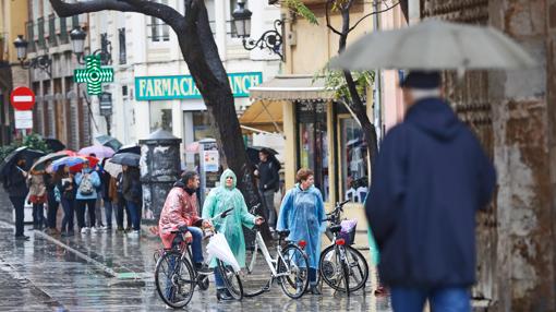 Varias personas se resguardan de la lluvia, este martes, en Valencia