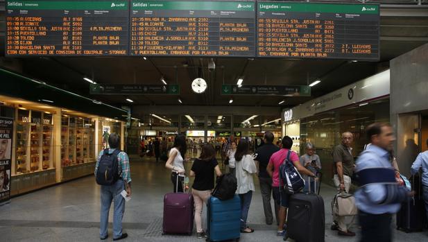 Viajeros miran los horarios en la estación madrileña de Atocha