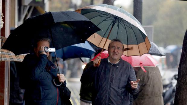 Unas personas se protegen de la lluvia, este lunes en Valencia