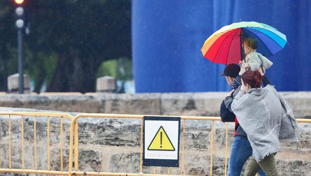 Unas personas se protegen de la lluvia de la pasada semana en Valencia