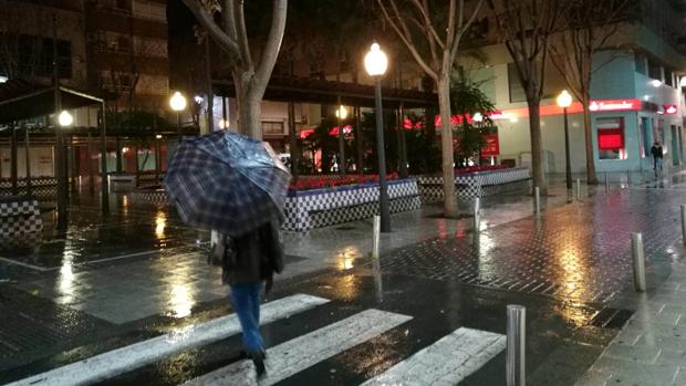 Una transeúnte camina por el centro de Elda, este viernes hacia las nueve de la noche