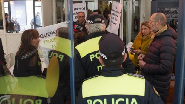 Los trabajadores y los dueños protestando mientras la Policía precinta el local