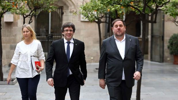 Puigdemont, esta mañana, con los consejeros Munté y Junqueras antes de la reunión semanal del Govern