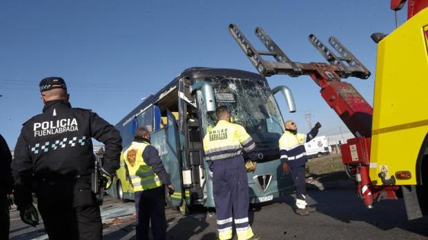 Los servicios de emergencias retiran con la grúa el autobús escolar accidentado en Fuenlabrada