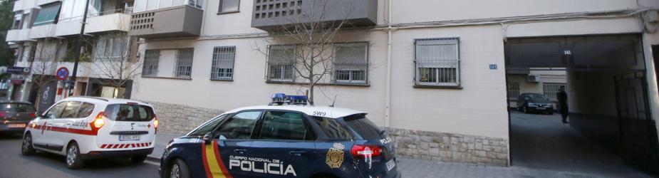 Un coche de Policía y otro de Cruz Roja en la entrada del edificio donde se han producido los hechos