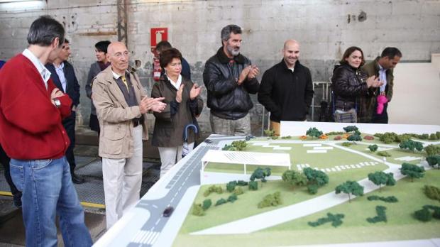 Varios de los cooperativistas contemplan la maqueta del proyecto para las cocheras de Cuatro Caminos