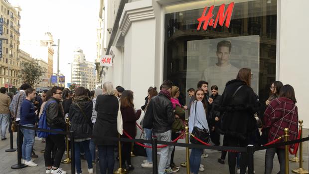 Decenas de personas hacen cola en la tienda de H&amp;M en la Gran Vía, 37
